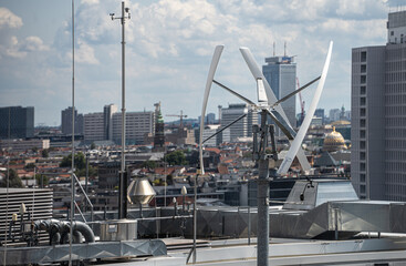 Vertical-axis wind turbine generating renewable energy on a rooftop