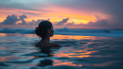 Woman soaking in a hot spring pool on the beach, small waves breaking in the background, colorful...