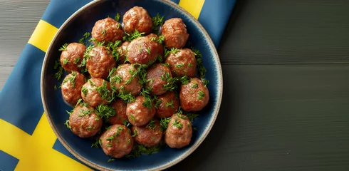 Foto op Aluminium Golden brown Köttbullar, the famous meatballs, present themselves as a delicious delicacy on a traditional Swedish plate. The background of the plate reflects a Scandinavian design and Swedish colors. © snapshotfreddy