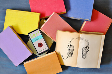 audio book concept with heap of books,generic drawing of vintage headphones and smartphone...