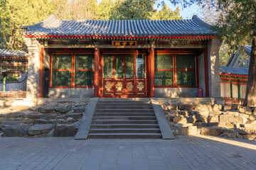 Obraz premium Front view of an old upper class Chinese house inside a palace complex with dominant red color, stone staircase towards the entrance, and Chinese writing that translates 