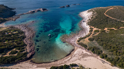 Aerial view of Cala Sapone, S. Antioco bay in Sardinia. Crystal clear sea, moored boat and white sand.