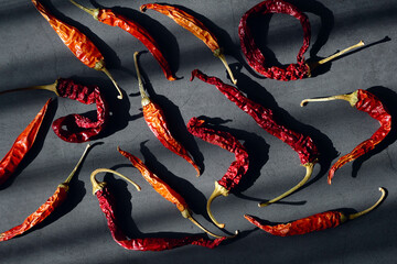 Hot red dried chili peppers on a dark background. Top view