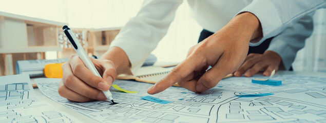 Worker, architect and engineer work on real estate construction project oratory planning with...
