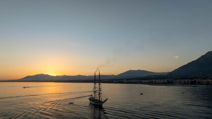 bonito atardecer en el mar junto a un barco velero