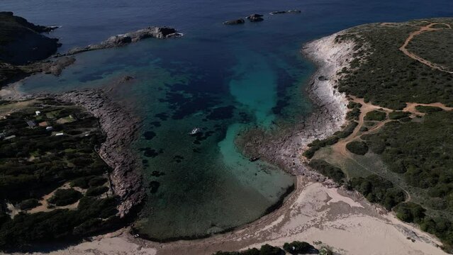 Aerial view of Cala Sapone, S. Antioco bay in Sardinia. Crystal clear sea, moored boat and white sand.