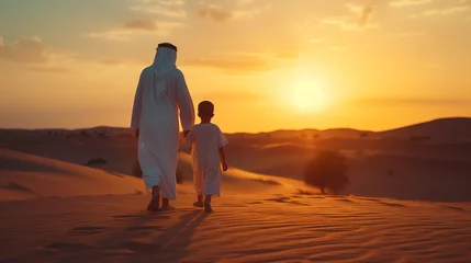 Poster Arab Father and son walking in the desert, Middle-eastern father and son wearing arab traditional kandura spending time in the desert, Dubai, © Fokke Baarssen