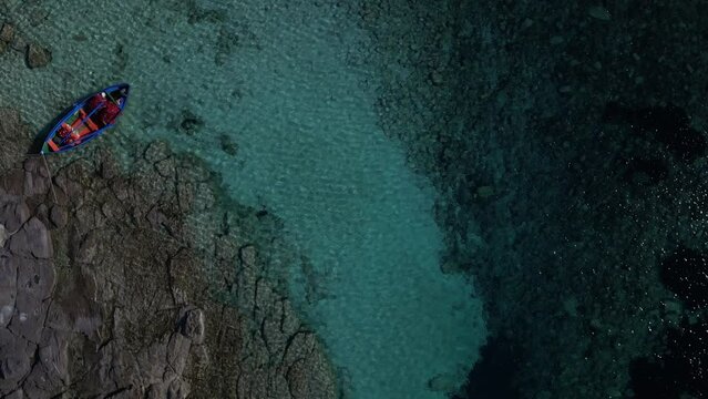 Aerial view of Cala Sapone, S. Antioco bay in Sardinia. Crystal clear sea, moored boat and white sand.