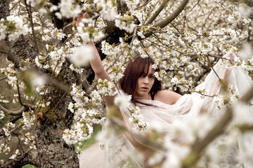 young seductive beauty brunette sexy woman portrait, spring positive emotions in blooming apple tree blossoms
