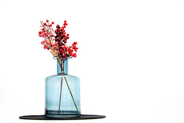 Fototapeta na wymiar Blue vase with red flowers on the table, isolated on white background