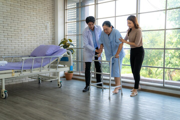 The physical therapist is assisting the patient in practicing walking, providing support for walking. The patient has pain in the ankle and a broken leg.