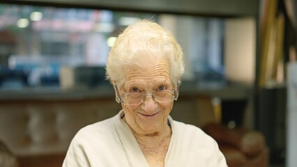 Old woman smiling at camera sitting in a nursing home