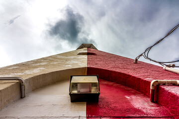 View of the old stone lighthouse tower in Georgetown, Guyana , South America against a background of a stormy sky with Cumulostratus clouds. Lighthouse - world tourism, attractions, landscape.