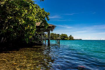 White Cirrus clouds over a lagoon in Samoan fale or hut or house  over calm blue water. A romantic quiet place for love and relaxation. Beauty clear cloudy in sunlight calm air background © DmitriiK