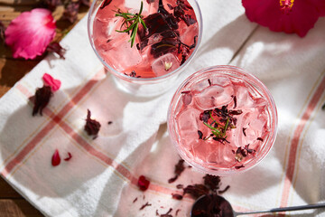 Obraz na płótnie Canvas Cold hibiscus tea, ice, herbs and hibiscus flowers