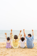 Happy Asian family enjoy and fun outdoor lifestyle travel nature ocean at tropical island beach on summer holiday vacation. Parents and little kids relaxing and playing together on the beach at sunset