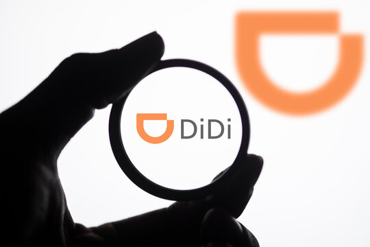 Dhaka, Bangladesh- 28 March 2024: A person holding a magnifying glass to inspect the logo of Didi.