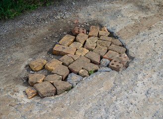 Fill potholes on the road with a piece of adobe