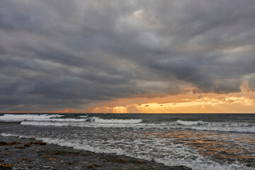amanecer con nubes de tormenta en una playa turística del mediterráneo 
