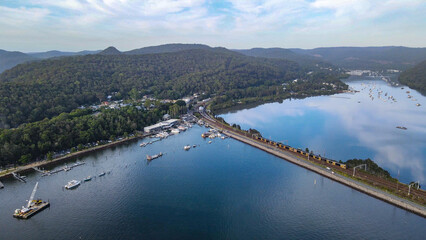 Aerial drone view of Hawkesbury River at Brooklyn, NSW Australia showing a train crossing Hawkesbury River during the early morning in February 2024  