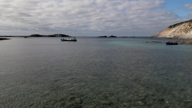 Aerial view of Cala Sapone, S. Antioco bay in Sardinia. Crystal clear sea, moored boat and white sand.