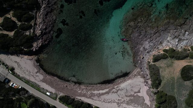 Aerial view of Cala Sapone, S. Antioco bay in Sardinia. Crystal clear sea, moored boat and white sand.