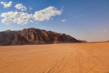 Fototapeta na wymiar desert valley with orange sand and rocky mountains