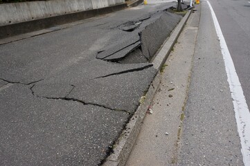 日本の石川県かほく市　地震による液状化現象で破損した道路
