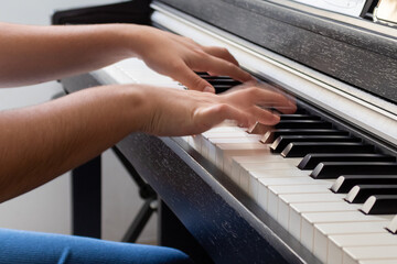 Manos con desenfoque por movimiento tocando piano. Musico en clase de piano.
