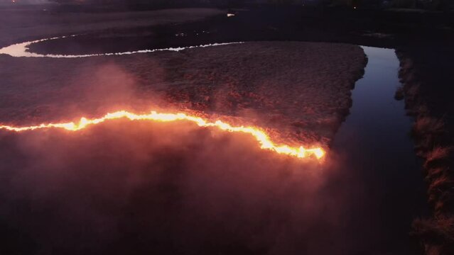 Aerial Nighttime View of Fire Encroaching on Waterway