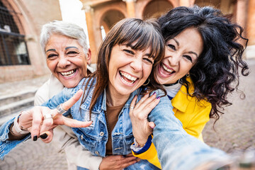 Three senior women taking selfie photo with smart mobile phone device outside - Happy aged people having fun together walking on city street - Life style concept with mature females hanging out - obrazy, fototapety, plakaty