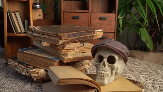 Skull, old books on the table.