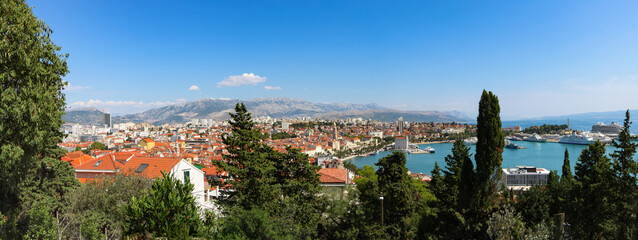 An unforgettable view of Split City, encompassing architecture, hills, trees, the sea, and boats.