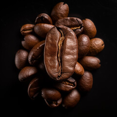 Fototapeta premium Roasted coffee beans scattered like dark, caffeinated jewels on a stark black canvas