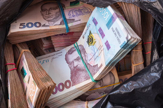 A lot of bundles of cash in black plastic bag. Close-up of Ukrainian money. Business concept.