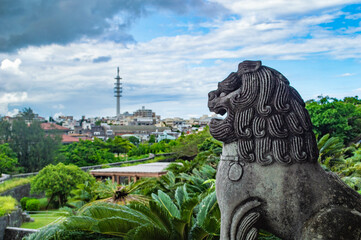 Statue de lion avec vue sur Naha depuis le château Shuri, Okianwa, Japon © luananasse