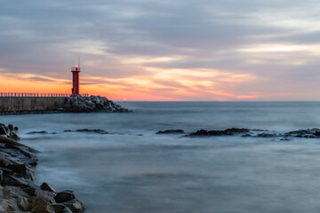 Beach scenery with dawn sky and lighthouse
