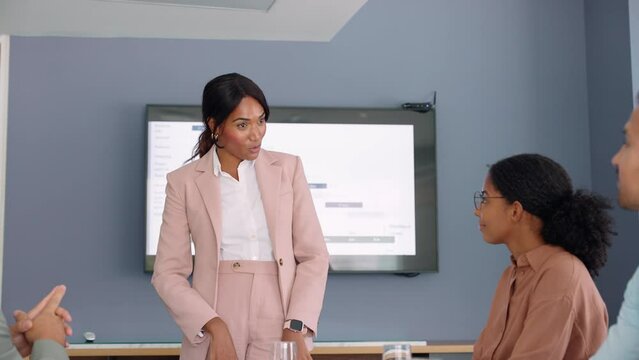 Smiling African American female executive company leader manager leading business presentation training meeting managing international corporate people team workers in office board room.