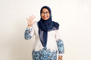 Asian elderly muslim woman standing while showing five fingers