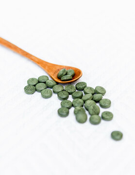 Groupe de pilules de spiruline sur fond blanc 