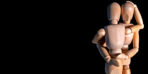 Innige Beziehung zwischen zwei Menschen dargestellt mit hölzernen Gliederpuppen vor schwarzem Hintergrund