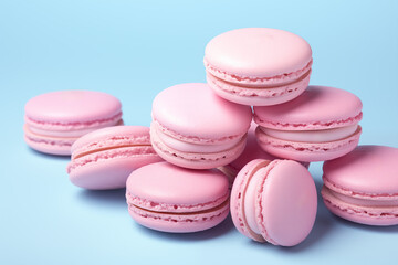 Obraz premium Stacked light pink macarons against a vibrant blue backdrop. Concept for bakery, dessert menu, or sweet treat promotion. Plenty of copy space.