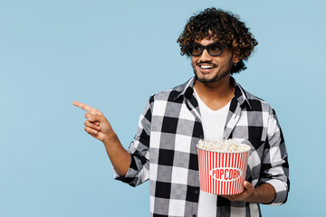 Young Indian man wear shirt white t-shirt casual clothes 3d glasses watch movie film hold bucket of...