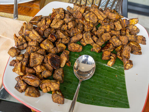 A Square White Plate Partially Filled with Small Dice-Sized Fried Beef Lungs
