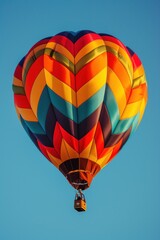Obraz premium Colorful Hot Air Balloon Soaring Through a Blue Sky