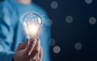 Hand man holding illuminated lightbulb, idea, innovation and inspiration with glowing virtual...