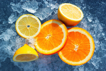 The sliced oranges and lemons on the natural ice. Fresh and vibrant fruits with vitamins for healthy nutrition.