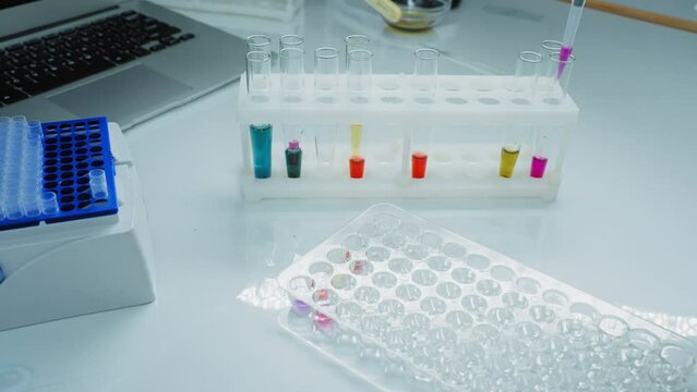 Female Research Scientist Uses Micropipette Filling Test Tubes in a Big Modern Laboratory. 