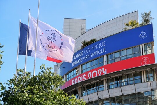Jeux olympiques (JO) d'&eacute;t&eacute;, "France olympique / France paralympique / Paris 2024" sur la fa&ccedil;ade de la Maison du Sport Fran&ccedil;ais, avec un drapeau du Comit&eacute; National Olympique et Sportif Fran&ccedil;ais (CNOSF)