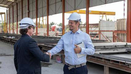 Two civil engineers from different cultures reach partnership agreement and have handshake in a prefabs or floor construction factory